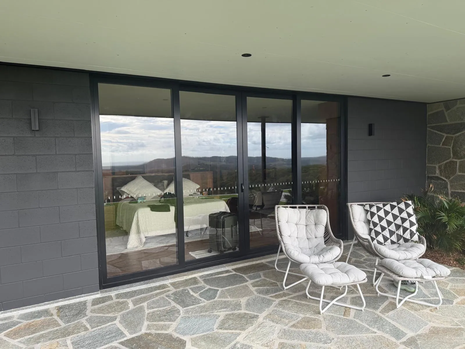 Wide sliding doors on a covered stone terrace looking out to the hinterland