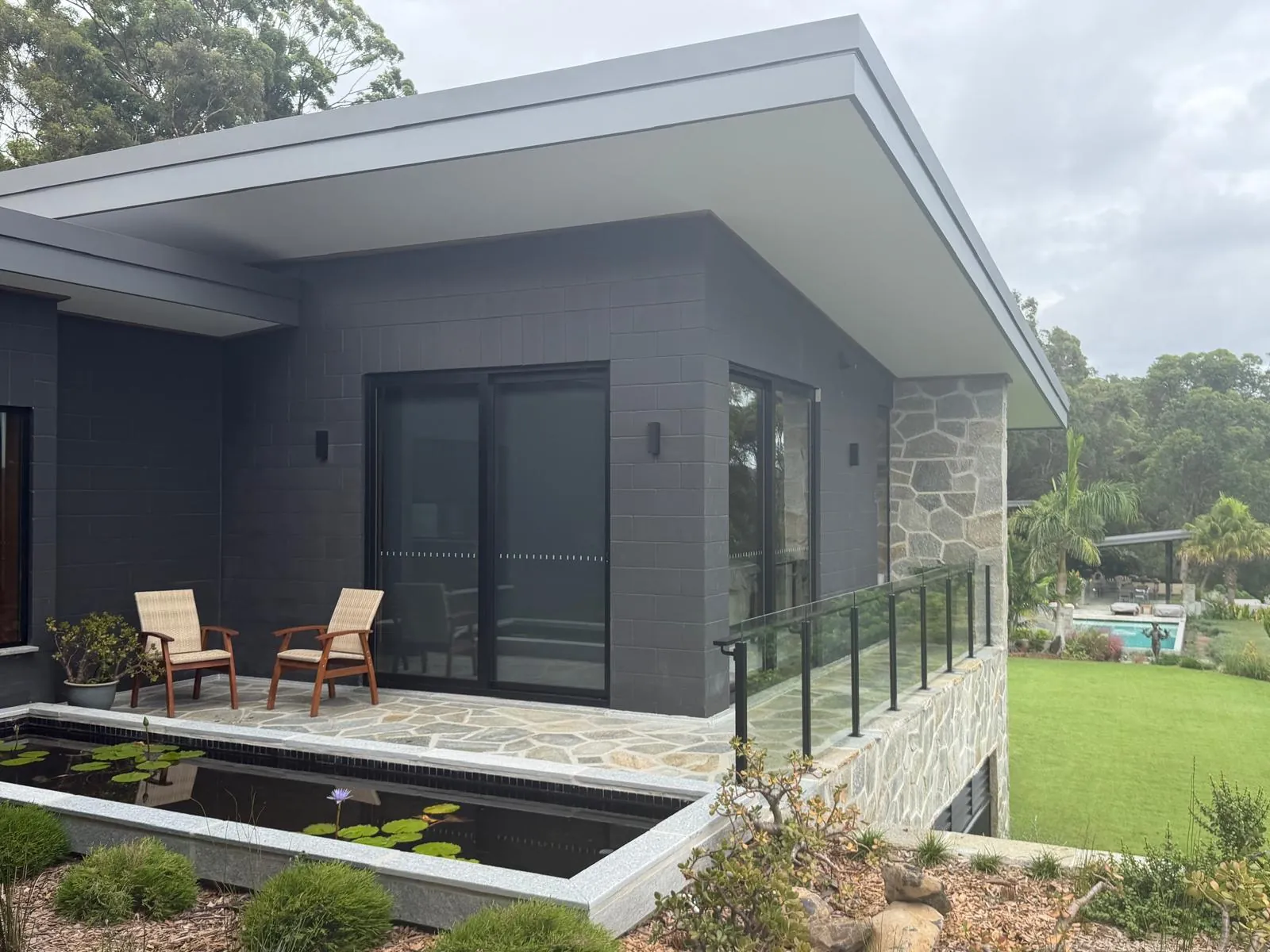 Exterior of the home with a reflection pond and sliding doors