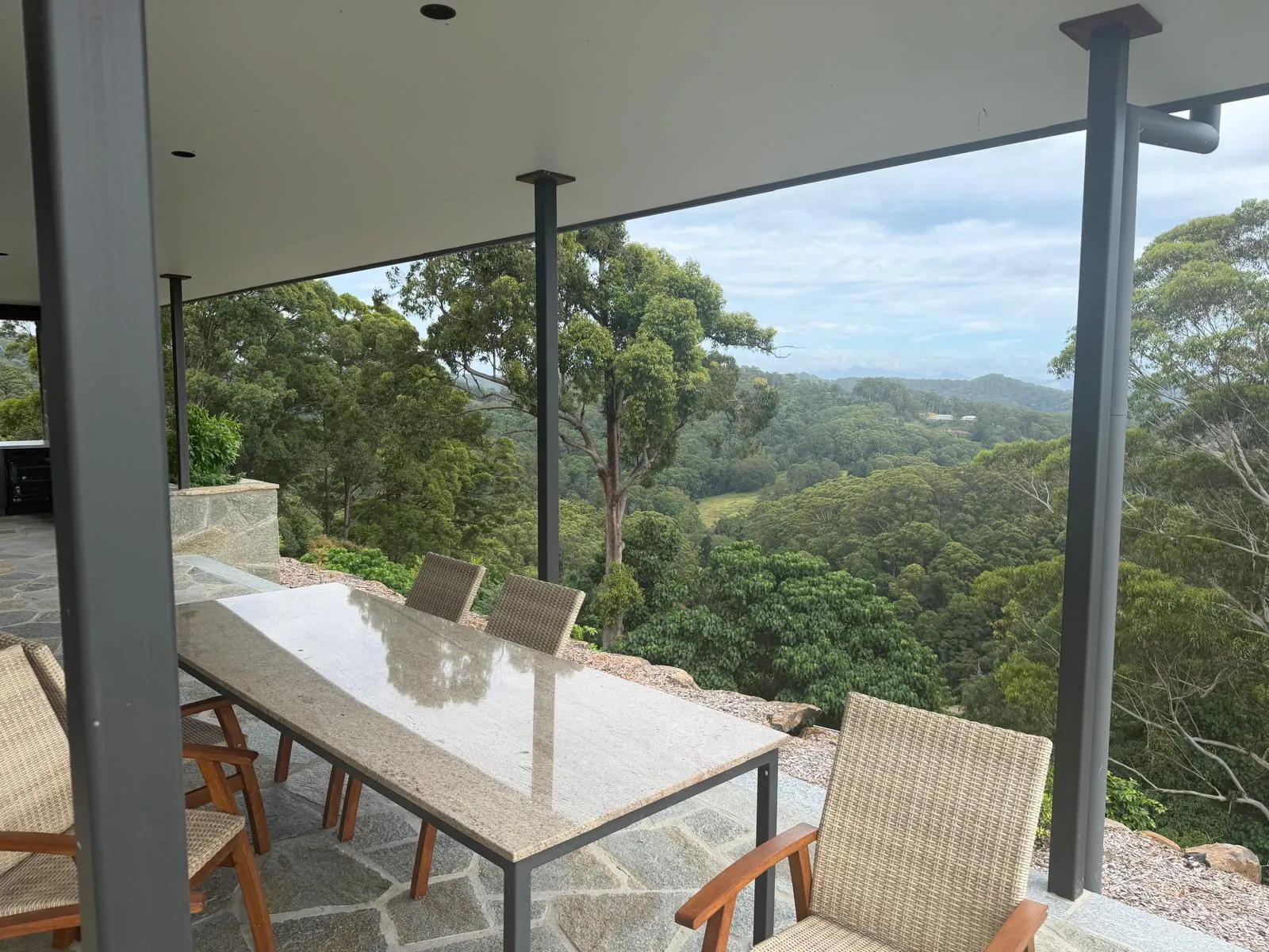 Outdoor dining area under the roof overhang with hinterland views